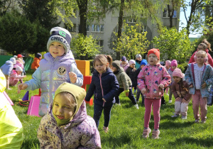 Dzieci biorą udział w zabawach ruchowych w ogrodzie przedszkolnym