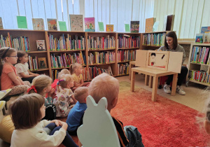 dzieci oglądają przedstawienie " Przygoda zwierząt z lasu" z wyk. teatrzyku kamishibai,