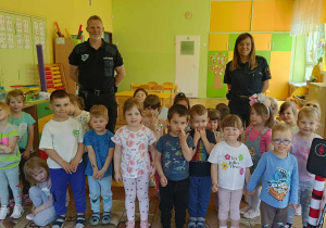 dzieci pozują do zdjęcia ze przedstawicielami straży miejskiej