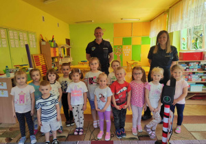 dzieci pozują do zdjęcia ze przedstawicielami straży miejskiej