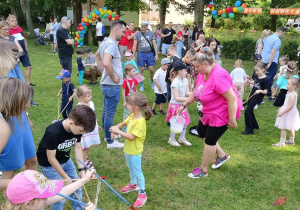 Dzieci wraz z rodzicami podczas wspólnych zabaw w ogrodzie przedszkolnym