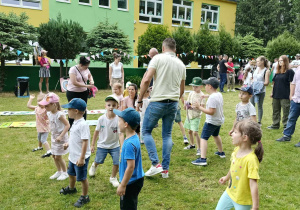 Dzieci wraz z rodzicami podczas wspólnych zabaw w ogrodzie przedszkolnym