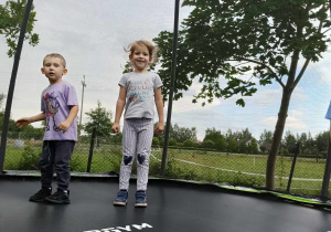 dzieci skaczą na trampolinie
