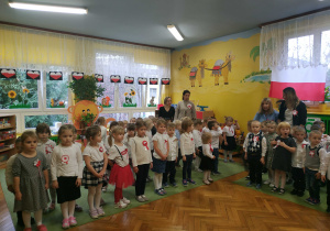 Dzieci z całego przedszkola, ubrane na galowo stoją i śpiewają "Mazurka Dąbrowskiego""