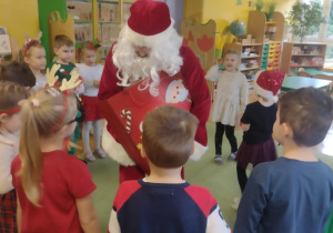 Mikołaj rozdaje prezenty dzieciom