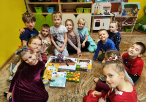 dzieci pozują do zdjęcia z prezentami od Mikołaja