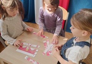 dziewczynki rozwiązują zadania, układając puzzle