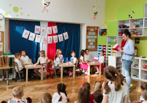 reprezentanci przedszkoli siedzą przy stolikach podczas quizu