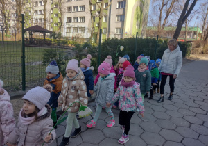 Dzieci maszerują korowodem wokół przedszkola, witając wiosnę