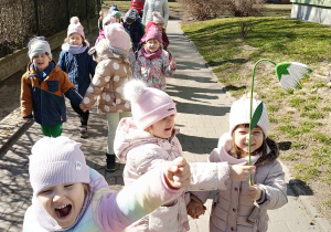 Dzieci maszerują korowodem wokół przedszkola, witając wiosnę