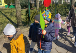 Dzieci maszerują korowodem wokół przedszkola, witając wiosnę