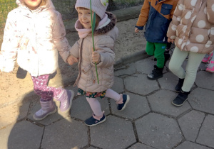 Dzieci maszerują korowodem wokół przedszkola, witając wiosnę