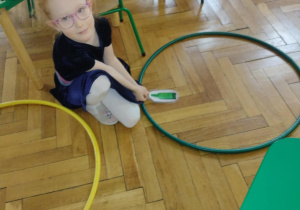 dzieci segregują śmieci do obręczy z odpowiednim kolorem