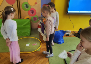dzieci segregują śmieci do obręczy z odpowiednim kolorem