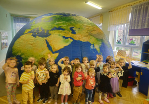 dzieci pozują do zdjęcia grupowego przed kopułą mobilnego planetarium