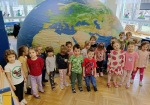 dzieci pozują do zdjęcia grupowego przed kopułą mobilnego planetarium