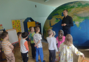 dzieci stoją przed mobilnym planetarium słuchając Pana edukatora
