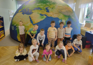 dzieci pozują do zdjęcia grupowego przed kopułą mobilnego planetarium