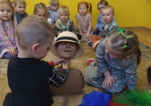 Dzieci z grupy zielonej poprzez zabawę oswajają się z fantomem do udzielania pierwszej pomocy. Ubierają w kolorowe apaszki i kapelusze fantom Annie.