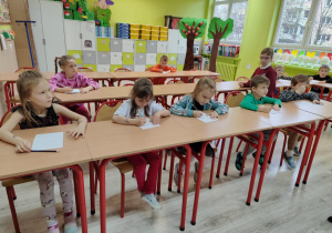 dzieci rozwiązują zadania: układają puzzle, rysują krasnoludka oraz wykonują zadanie matematyczne