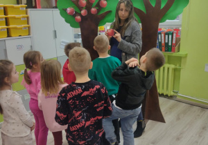 Dzieci szukają na drzewie jabłek