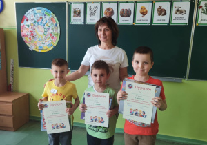 dzieci biorące udział w konkursie pozują do zdjęcia z dyplomami i nagrodami