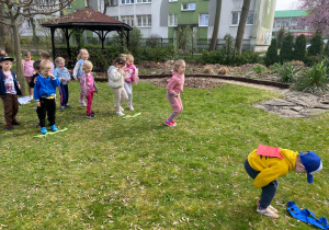 Dzieci biorą udział w konkurencjach sportowych w ogrodzie przedszkolnym.
