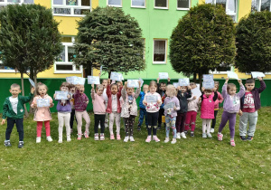 dzieci pozują do zdjęcia grupowego, w ręku trzymają dyplom