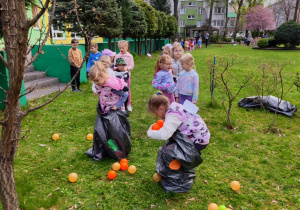 Dzieci biorą udział w konkurencjach sportowych w ogrodzie przedszkolnym.