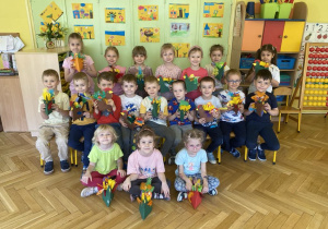 dzieci prezentują swoje ozdoby pozując do zdjęcia grupowego
