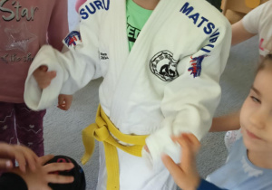 dzieci przymierzają strój do trenowania judo