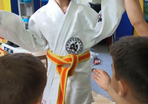 dzieci przymierzają strój do trenowania judo