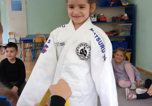 dzieci przymierzają strój do trenowania judo