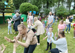 dzieci wraz z rodzicami tańczą do muzyki