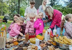 dzieci wraz z rodzicami przy słodkim poczęstunku