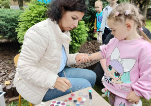 dziewczynka ma wykonywany tatuaż brokatowy