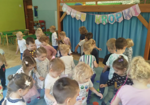 Dzieci biorą udział w zabawie ruchowej, omijając kolorowe kropki