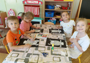dzieci wykonują prace plastyczne z wykorzystaniem pasteli