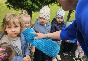 dzieci stoją na tarasie przedszkolnym, pani Dyrektor trzyma pluszową kredkę pasując dzieci na przedszkolaków
