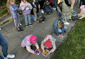 dzieci wykonują „mural” malując kleksami farby na kartce zamkniętej w woreczku strunowym