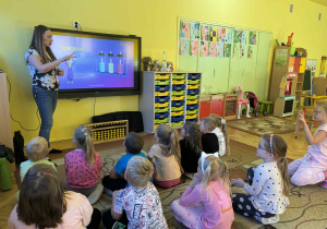 dzieci rozwiązują zadanie matematyczne na monitorze edukacyjnym