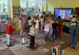 dzieci dostosowują ruch ciała do odpowiedniej cyfry na liczydle