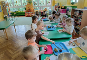 dzieci kroją i obierają owoce