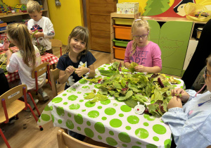 dzieci nawlekają na drucik kreatywny liście tworząc gąsienicę