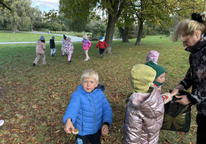 dzieci zbierają w parku kasztany