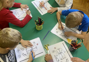 dzieci w przy stolikach wykonują prace plastyczne