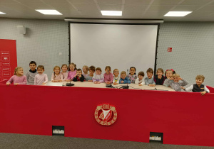dzieci stoją w sali konferencyjnej, pozują do zdjęcia