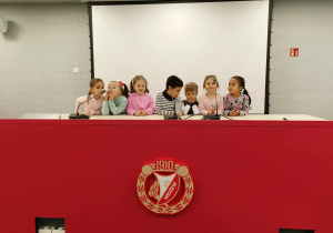 dzieci stoją w sali konferencyjnej, pozują do zdjęcia
