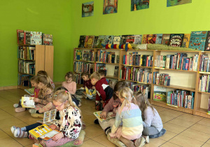dzieci oglądają w bibliotece książki
