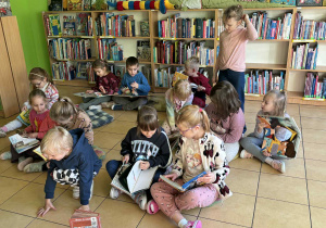 dzieci oglądają w bibliotece książki
